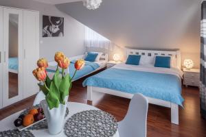 a bedroom with two beds and a table with a vase of flowers at Villa Marta in Augustów