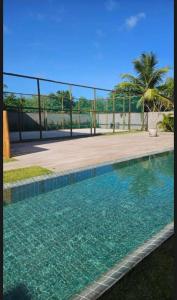 a swimming pool in front of a fence at Casa Aroeira Milagres in São Miguel dos Milagres