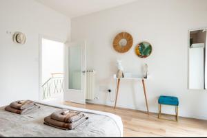 a white bedroom with a bed and a blue stool at Casa Il sole, vicino Deruta Assisi Perugia Monte Falco in Deruta