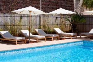 a group of chairs and umbrellas next to a swimming pool at La Garoupe-Gardiole in Antibes