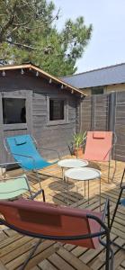 a deck with chairs and tables and a house at Ty Gwenn in La Baule +4 photos