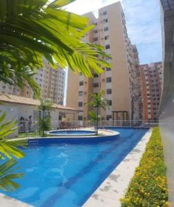a large swimming pool with palm trees and buildings at Apartamento completo 3 quartos in Belém