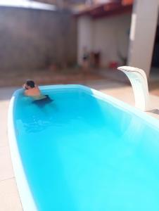 un uomo che galleggia in una piscina in una piscina di Residência em Bairro Nobre a Imperatriz