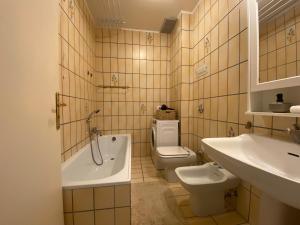 a bathroom with a tub and a toilet and a sink at Monticella Haus Apartment in San Vendemiano +1 photo