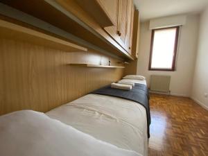 three beds in a row in a room with a window at Monticella Haus Apartment in San Vendemiano