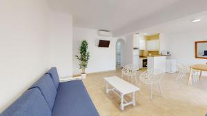 a living room with a blue couch and a table at Apartamentos Concorde in Alicante