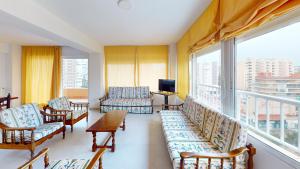 a living room with chairs and a large window at Apartamentos Concorde in Alicante