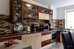 a kitchen with wooden cabinets and a counter top at Green House Arini in Sibiu
