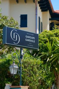 a blue street sign on a light pole at La Garoupe-Gardiole in Antibes