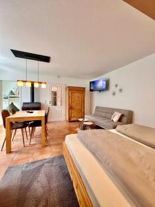 a living room with a couch and a table at Hasenchalet Ruhpolding, familienfreundlich, Badewanne, Chiemgau-Karte inklusive in Ruhpolding