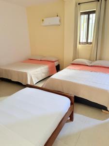 a room with three beds and a window at Hotel Rosandy Galaxy in Cartagena de Indias +16 photos