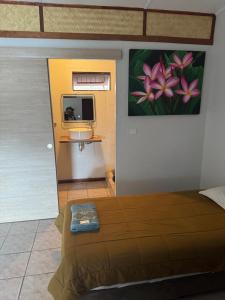 La FoaにあるLe Fautauaのベッドと壁に絵が飾られた寝室
