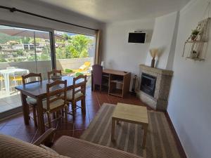 a living room with a table and a fireplace at Verde Pinho in Geres