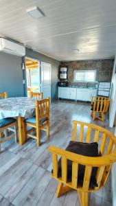 a dining room with a table and chairs and a kitchen at Los Sauces, casas con piscinas privadas en barrio residencial in San Carlos de Bolívar +16 photos