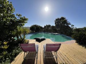 two chairs sitting on a deck next to a swimming pool at Monte D´Sancho in Aljezur