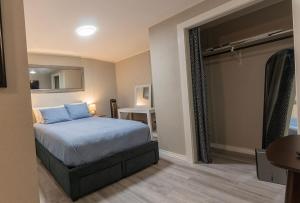 Schlafzimmer mit einem Bett mit blauer Bettwäsche und einem Spiegel in der Unterkunft Downtown Eureka, 1 Queen bed, full kitchen, free parking in Eureka Springs