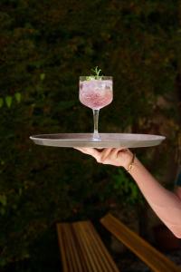 a person holding a glass with a plant on a tray at La Garoupe-Gardiole in Antibes