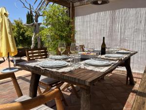 a wooden table with glasses of wine on a patio at Monte D´Sancho in Aljezur