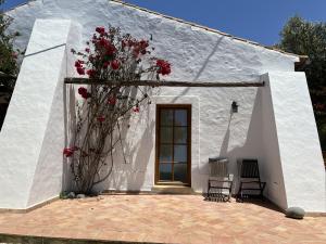 a white building with red flowers on it at Monte D´Sancho in Aljezur