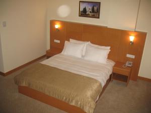 a bedroom with a large bed with white sheets and pillows at Shilla Hotel in Velimeşe