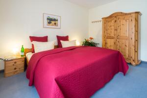 Hotel Fontana - ADULTS ONLY في باد برايسيغ: غرفة نوم مع سرير وردي وخزانة خشبية