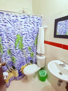 a bathroom with a shower curtain with a toilet and a sink at Hotel Rosandy Galaxy in Cartagena de Indias