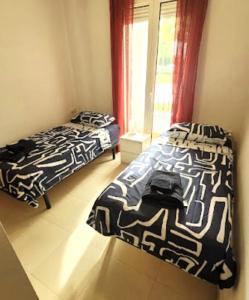 two beds sitting in a room with a window at Ground floor family apartment, Close to Town and pool in Casas del Cura