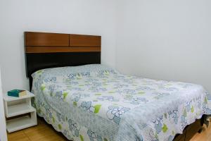 a bedroom with a bed with a blue and white comforter at DEPARTAMENTO AMOBLADO in Tacna