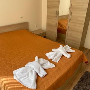 a bed with towels on it in a bedroom at Тристаен апартамент в затворен комплекс in Chernomorets +11 photos