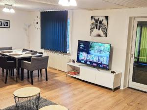 a living room with a dining table and a television at 8 person holiday home in Øster Assels-By Traum in Øster Assels