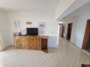a living room with a television on a wooden cabinet at Guest House Gordana in Banjol