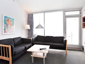 a living room with a black couch and a table at Apartment with loft in Ringkøbing in Ringkøbing
