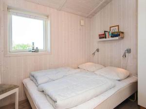 a large bed in a room with a window at 4 star holiday home in Hejls in Hejls