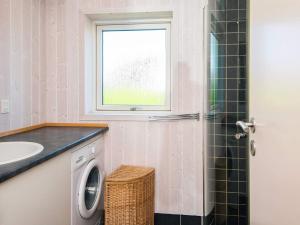 a bathroom with a washing machine and a window at 4 star holiday home in Hejls in Hejls +32 photos