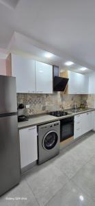 a kitchen with white cabinets and a dishwasher at superb appartement in Kelibia