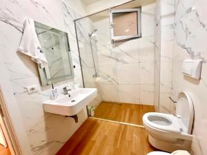 a bathroom with a sink and a toilet at Luxury apartment - parking, pool and beach access in Vlorë