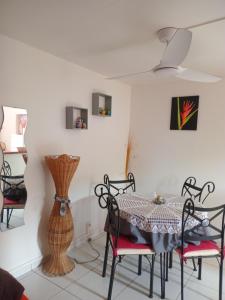 a dining room with a table and chairs and a vase at Divima in Sainte-Anne