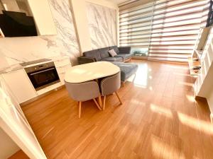 a living room with a couch and a table at Luxury apartment - parking, pool and beach access in Vlorë