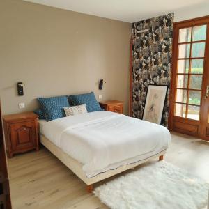 a bedroom with a large white bed with blue pillows at Magnifique villa au cœur de la nature in Marigny-en-Orxois