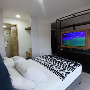 una camera con letto e TV a parete di Apartaestudio Moderno a Cali