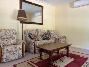 - un salon avec un canapé, une chaise et un miroir dans l'établissement School Cottage, à Walhalla