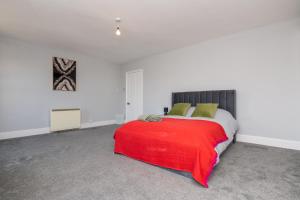 Un dormitorio con una cama con una manta roja. en The Harwich Hideaway, en Harwich