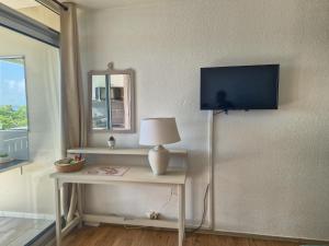 Et tv og/eller underholdning på Appartement terrasse vue mer et piscine