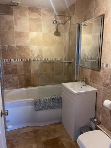 Un baño con bañera, lavabo e inodoro. en Seaside Retreat Family Getaway in Saundersfoot, en Pembrokeshire