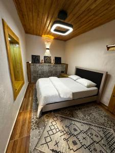 a bedroom with a large bed with a rug at Silenos Stone House Sille Antiq City in Sille +1 photo