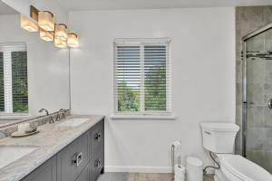 a white bathroom with a toilet and a sink at Bass Alley Bungalow Experience Wc Lodging in Lower Lake +26 photos