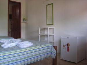 um quarto com uma cama e um frigorífico em Pousada Casa Verde Boipeba na Ilha de Boipeba