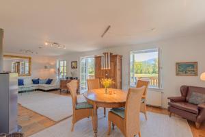 a kitchen and living room with a table and chairs at 5 Sterne FeWo mit Garten und Bergblick in Chiemsee-Nähe in Übersee
