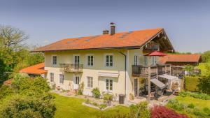 a large house with an orange roof at 5 Sterne FeWo mit Garten und Bergblick in Chiemsee-Nähe in Übersee
