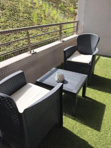 three chairs and a table on a balcony at Le cocon d'Elodie in Belley +10 photos